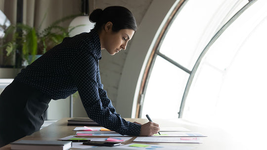 Manager in office on her own writing out a plan